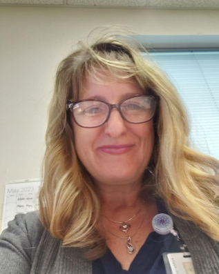 woman with glasses smiles at the camera